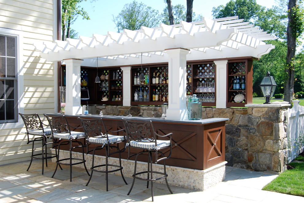 Medium sized classic back patio in New York with an outdoor kitchen, natural stone paving and a pergola.