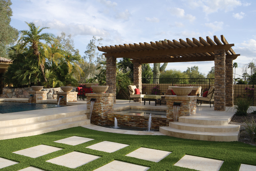 Idee per un ampio patio o portico classico dietro casa con un focolare, pavimentazioni in pietra naturale e una pergola