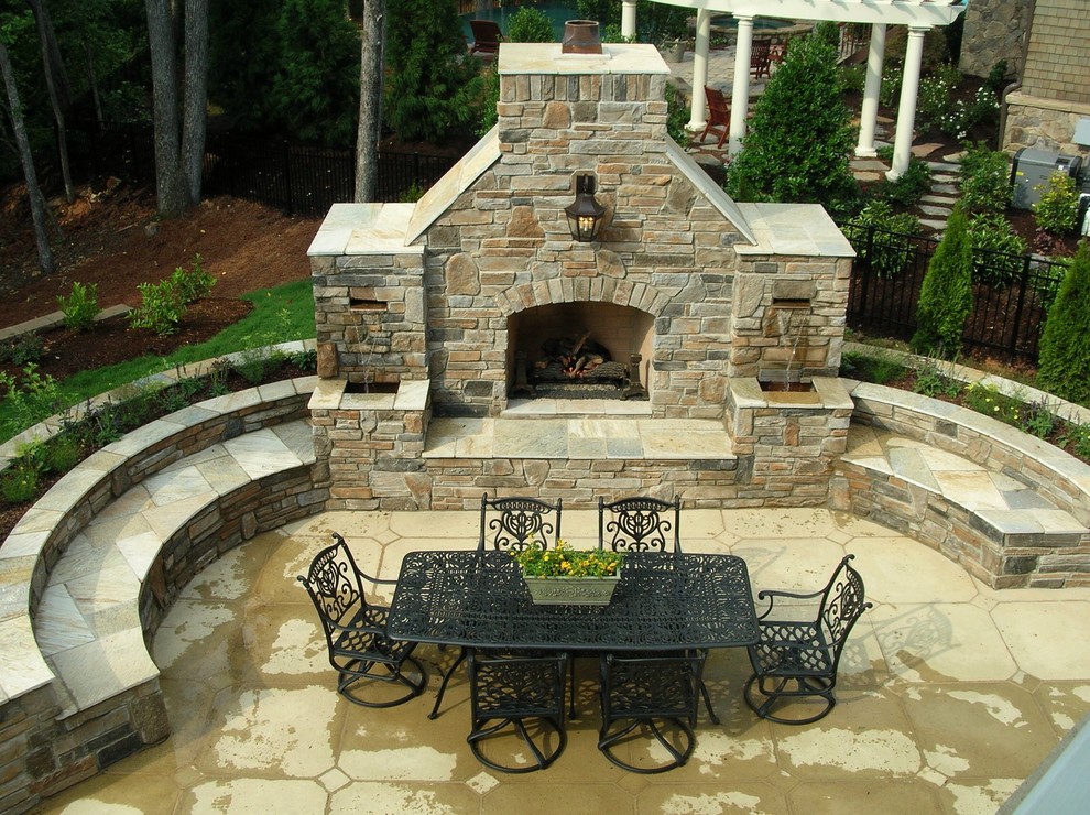 Expansive classic back patio in Charlotte with a fire feature, stamped concrete and no cover.