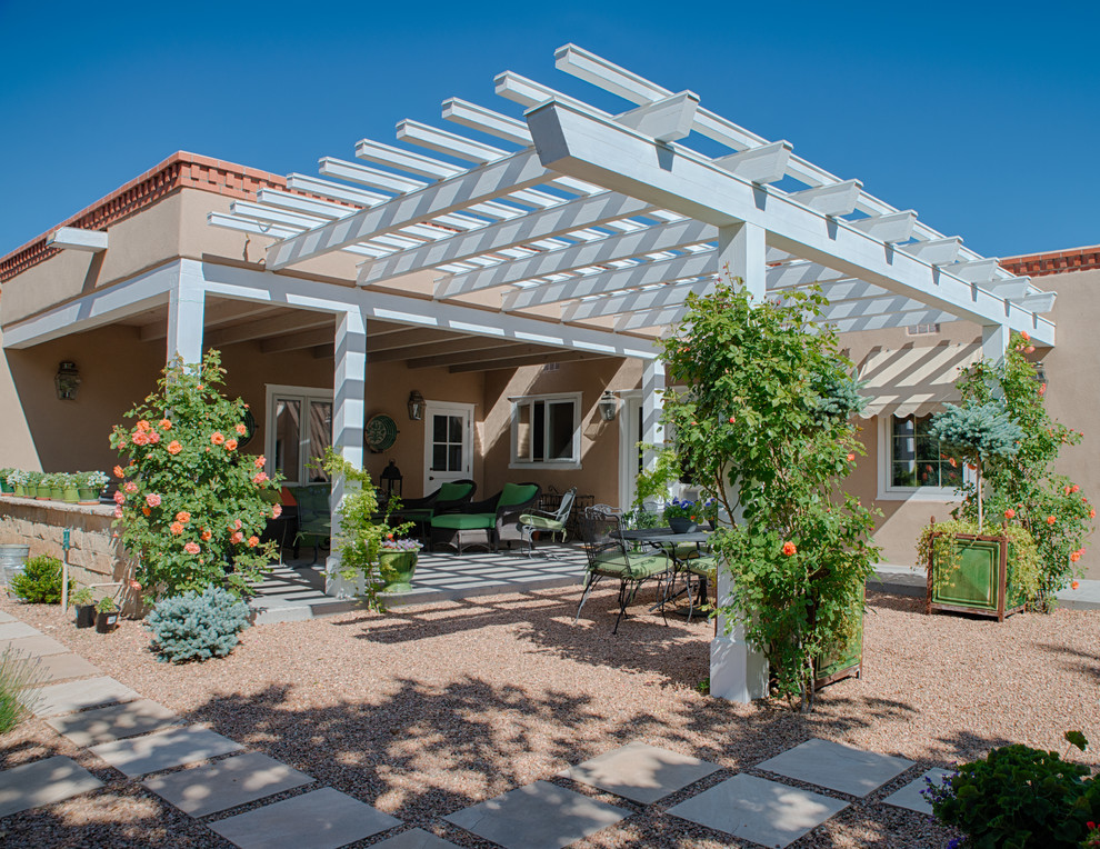 Photo of a large back patio in Albuquerque with gravel and a pergola.