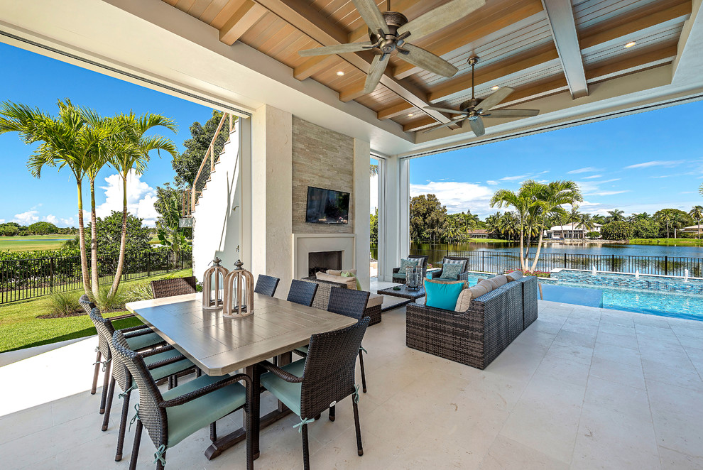 Example of a beach style backyard tile patio design in Other with a roof extension and a fireplace