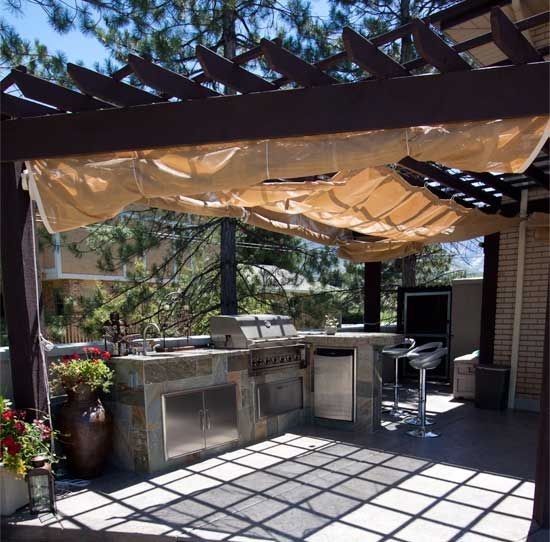 Aménagement d'une terrasse arrière avec une cuisine d'été et une pergola.