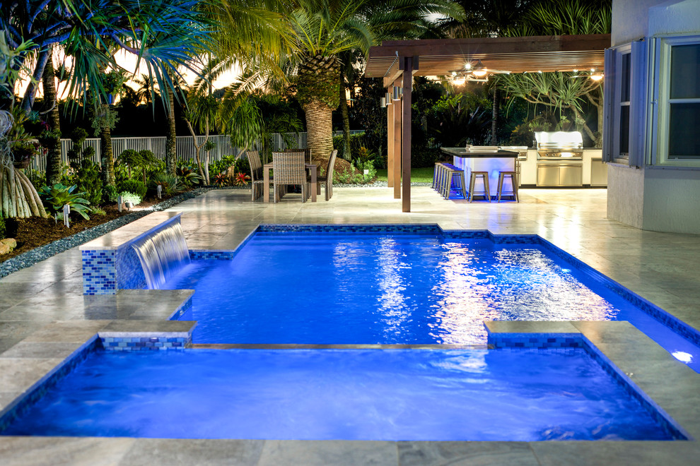 Mittelgroßer Moderner Pool hinter dem Haus mit Natursteinplatten in Miami
