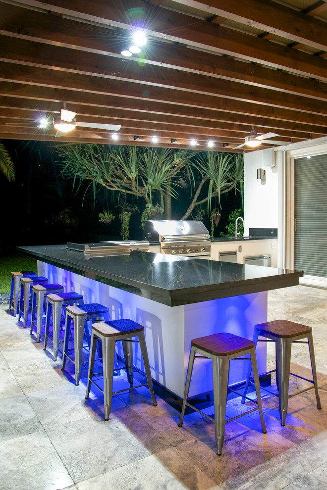 Großer Moderner Patio hinter dem Haus mit Outdoor-Küche, Natursteinplatten und Markisen in Miami