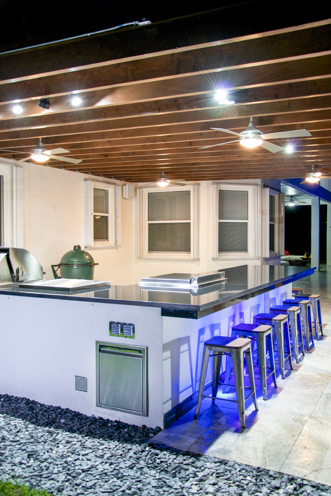 Patio kitchen - large contemporary backyard stone patio kitchen idea in Miami with a pergola
