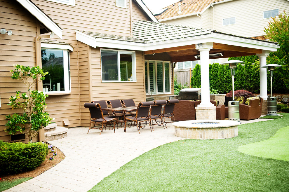Esempio di un patio o portico classico di medie dimensioni e dietro casa con un focolare, graniglia di granito e nessuna copertura