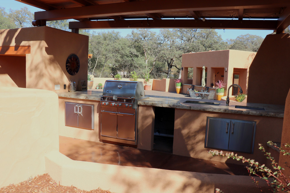 Inspiration pour une terrasse arrière sud-ouest américain de taille moyenne avec une cuisine d'été, une dalle de béton et un auvent.