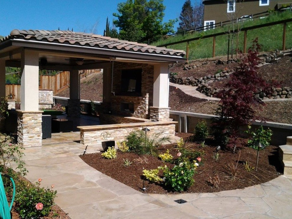 Inspiration for a large mediterranean backyard stone patio kitchen remodel in San Francisco with a gazebo