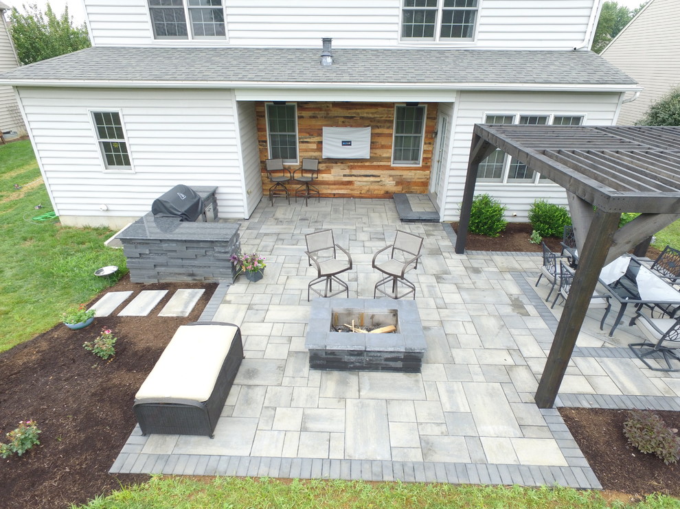 Immagine di un patio o portico dietro casa con pavimentazioni in cemento e una pergola