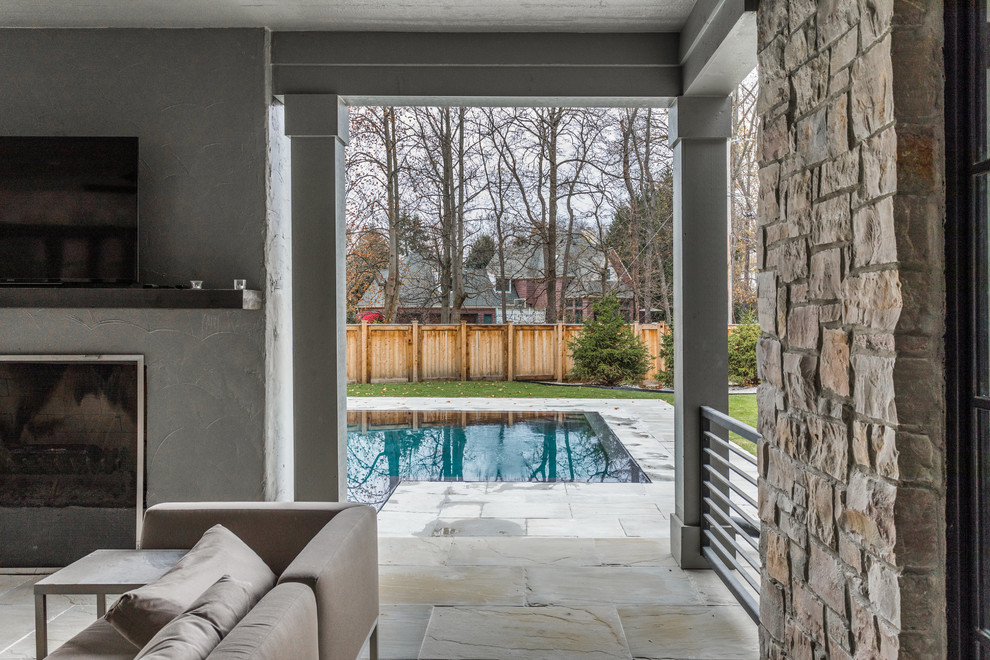 Immagine di un grande patio o portico minimal dietro casa con piastrelle e un tetto a sbalzo
