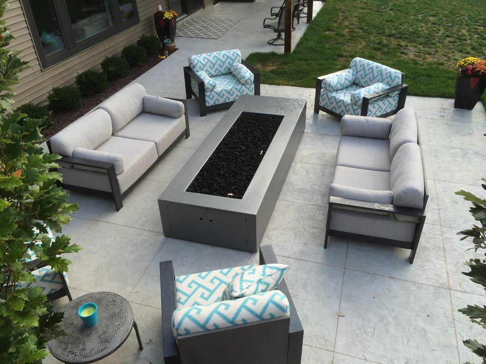 Inspiration for a large contemporary back patio in Cedar Rapids with a fire feature, concrete paving and no cover.