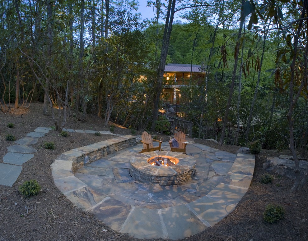 Patio - large traditional backyard stone patio idea in Other with a fire pit and no cover