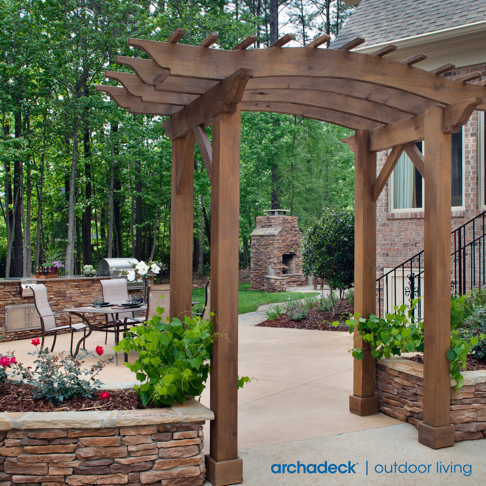 Design ideas for an expansive traditional back patio in Charlotte with a fire feature, stamped concrete and a pergola.