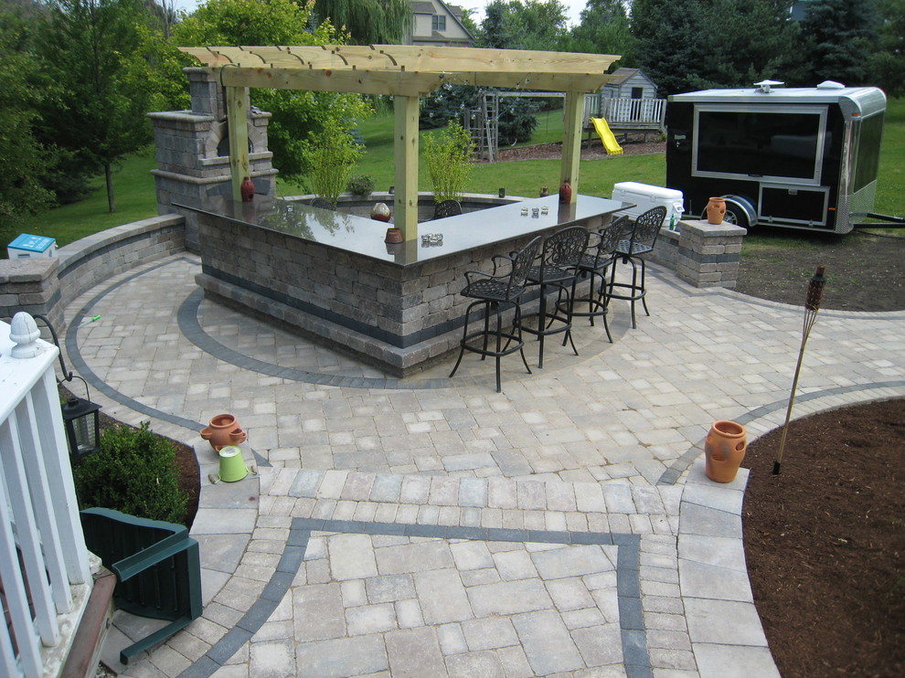 Patio - small tropical backyard brick patio idea in Chicago with a fireplace and a pergola