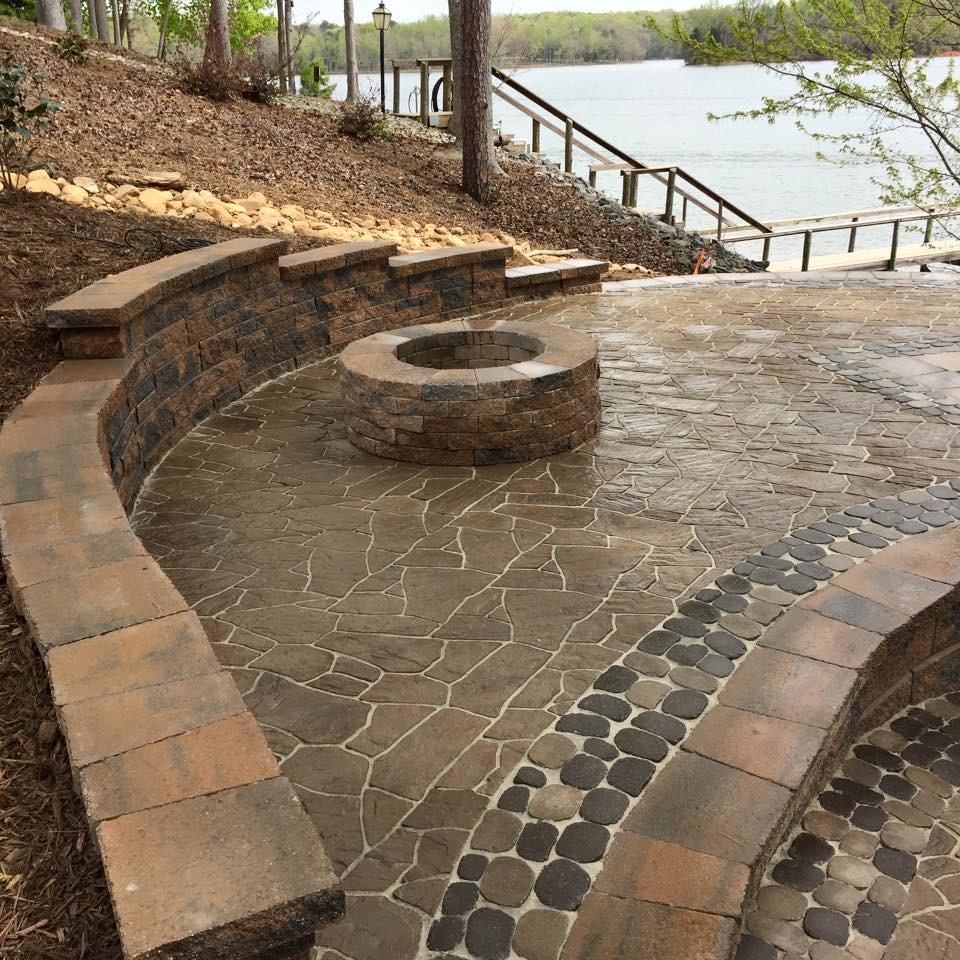 Patio - large traditional backyard stone patio idea in Charlotte with a fire pit and no cover