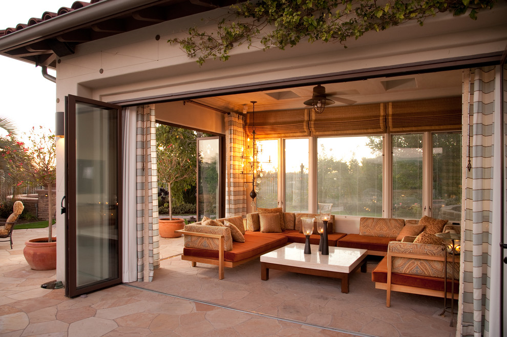 Großer Mediterraner Patio hinter dem Haus mit Natursteinplatten und Gazebo in Los Angeles
