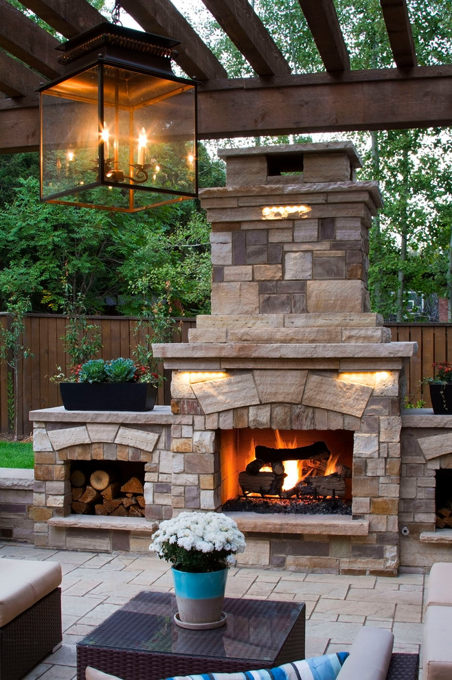 Large transitional backyard stone patio photo in Denver with a fireplace and a pergola