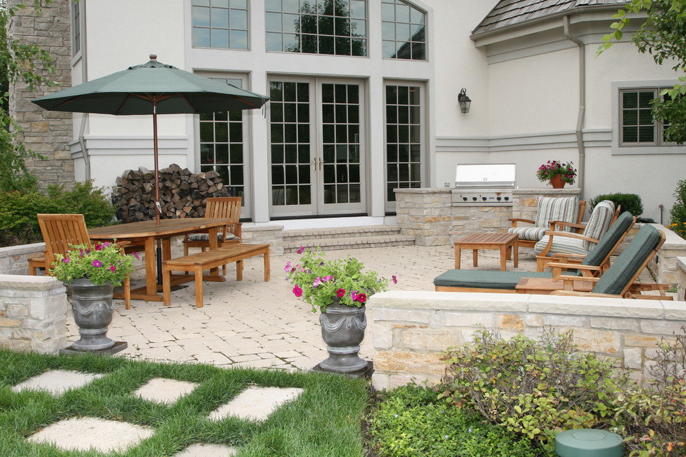 Cette photo montre une terrasse arrière chic avec des pavés en béton, aucune couverture et une cuisine d'été.