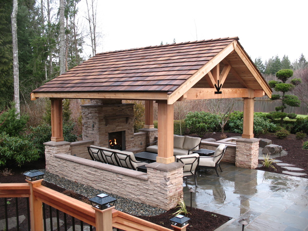 Diseño de patio clásico en patio trasero con adoquines de piedra natural y pérgola