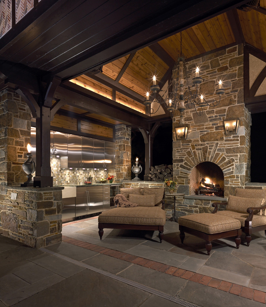 Photo of a classic side patio in Philadelphia with a fire feature, a gazebo and natural stone paving.