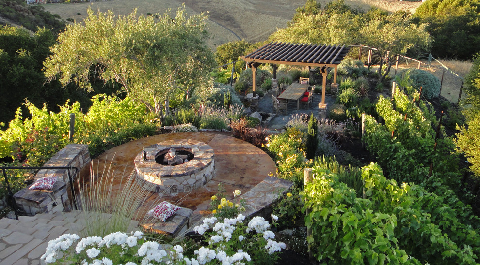 Foto de patio tradicional de tamaño medio en patio trasero con brasero y adoquines de ladrillo