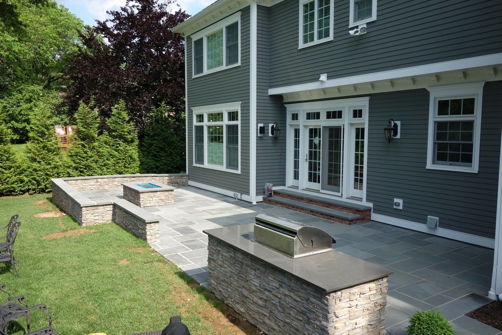 Imagen de patio actual grande sin cubierta en patio trasero con brasero y adoquines de piedra natural