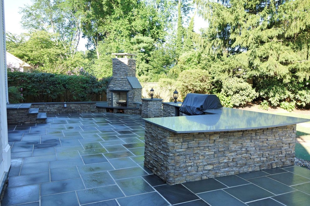 Patio kitchen - large traditional backyard stone patio kitchen idea in New York with no cover