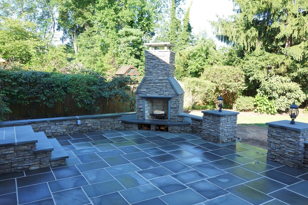 Foto di un grande patio o portico classico dietro casa con pavimentazioni in pietra naturale e nessuna copertura