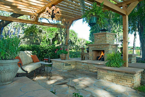 Imagen de patio clásico renovado de tamaño medio en patio trasero con brasero, adoquines de piedra natural y pérgola