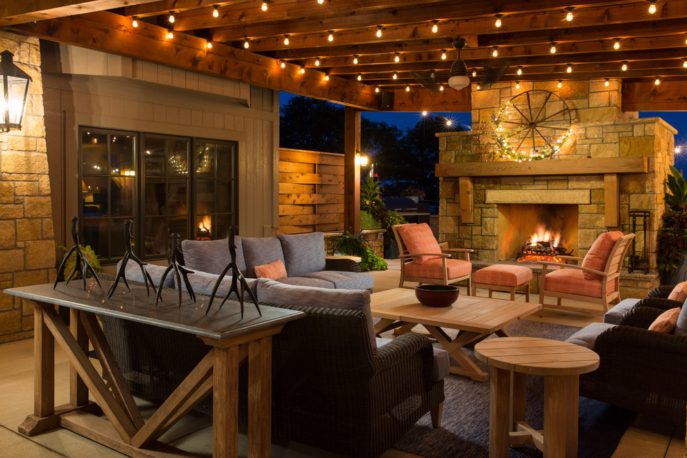 Design ideas for a large rustic back patio in Kansas City with concrete slabs, an awning and a fireplace.