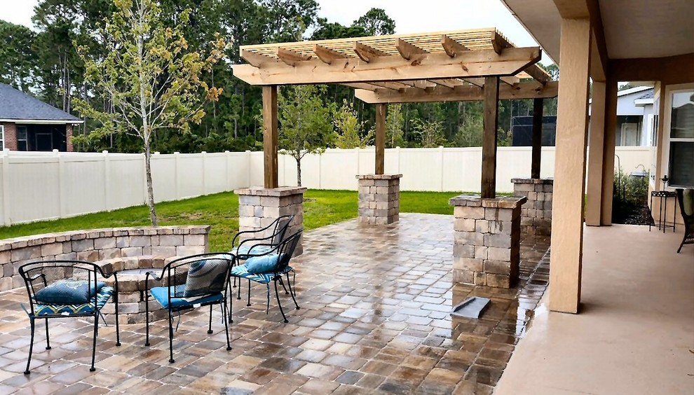 Inspiration for a mid-sized timeless backyard brick patio remodel in Jacksonville with a fire pit and a pergola