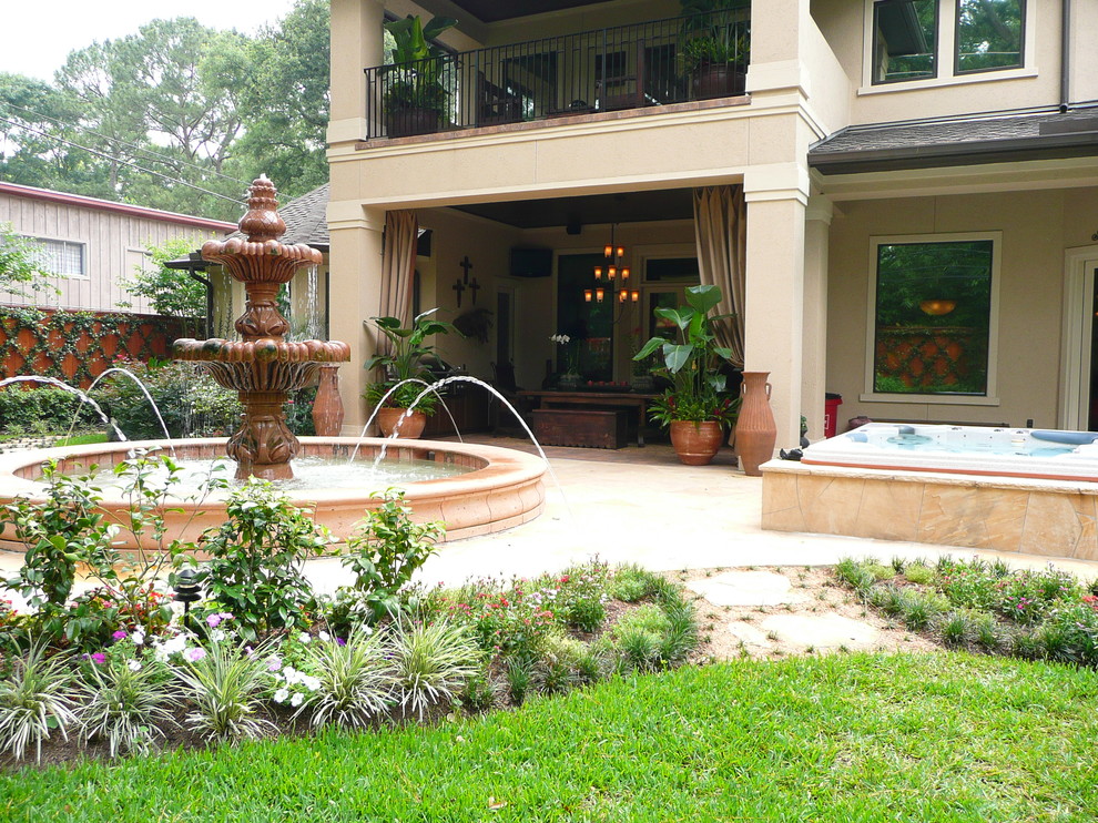 Photo of a medium sized bohemian back patio in Houston with a water feature, natural stone paving and a roof extension.