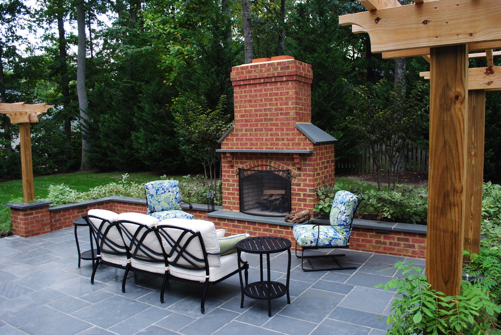 Imagen de patio clásico pequeño en patio trasero con pérgola, brasero y adoquines de piedra natural