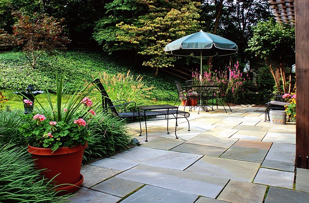 Diseño de patio clásico de tamaño medio en patio trasero con adoquines de piedra natural