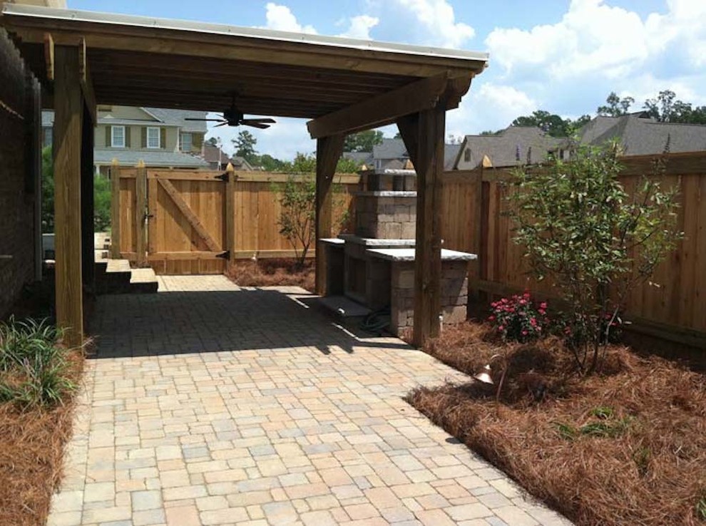 Inspiration for a large traditional back patio in Jackson with an outdoor kitchen, natural stone paving and a gazebo.