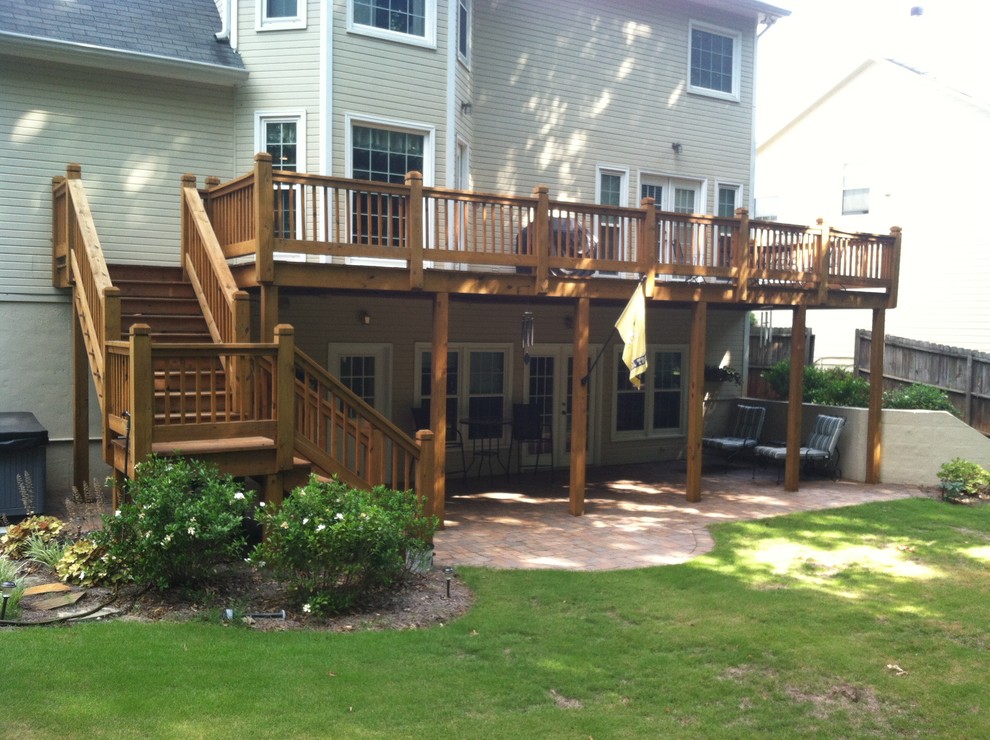 Exemple d'une terrasse arrière chic de taille moyenne avec un foyer extérieur, des pavés en béton et une extension de toiture.