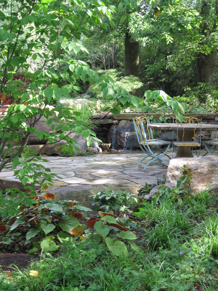 Idéer för att renovera en mellanstor vintage uteplats på baksidan av huset, med naturstensplattor och en fontän