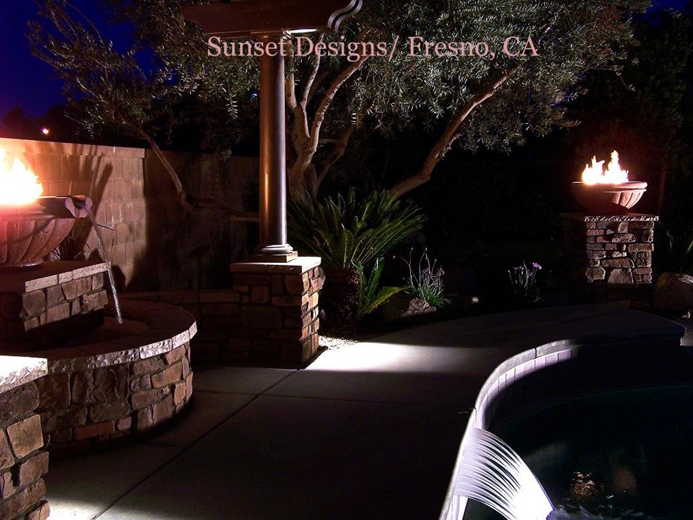 Photo of a large classic back patio in Other with a fire feature, concrete slabs and a pergola.