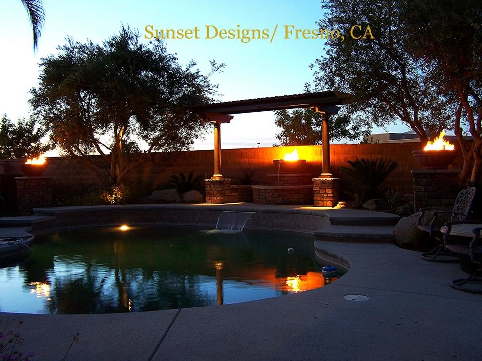 Photo of a large mediterranean back patio in Other with a fire feature, concrete slabs and a pergola.