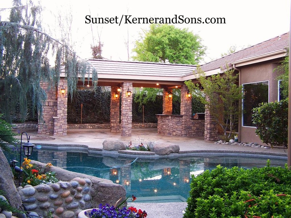 Example of a large southwest backyard stone patio kitchen design in Other with a roof extension