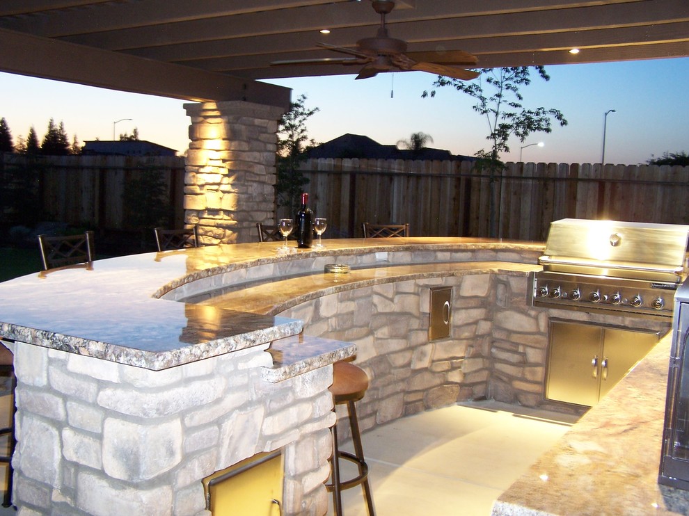 Inspiration for a mid-sized craftsman backyard concrete patio kitchen remodel in Other with a pergola
