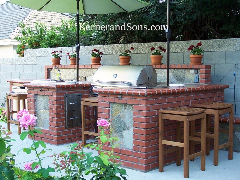 Large elegant backyard concrete patio kitchen photo in Other with no cover
