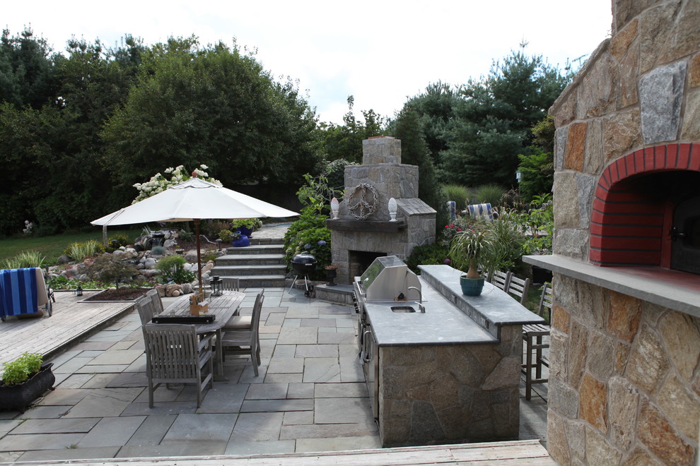 Aménagement d'une terrasse arrière classique avec une cuisine d'été et une pergola.