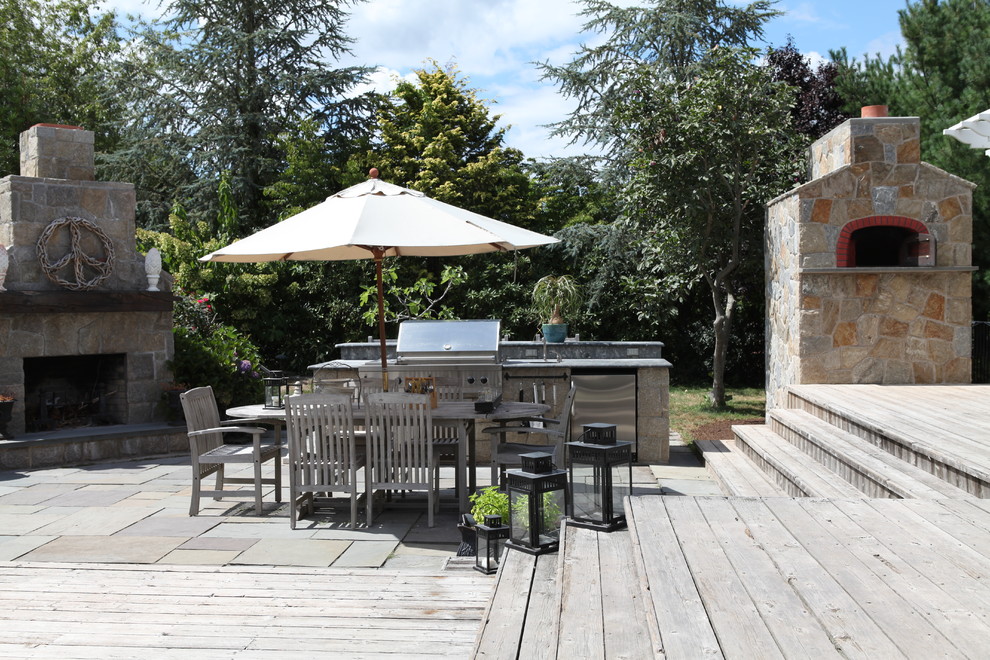 Inspiration for a large classic back patio in New York with an outdoor kitchen, decking and a pergola.