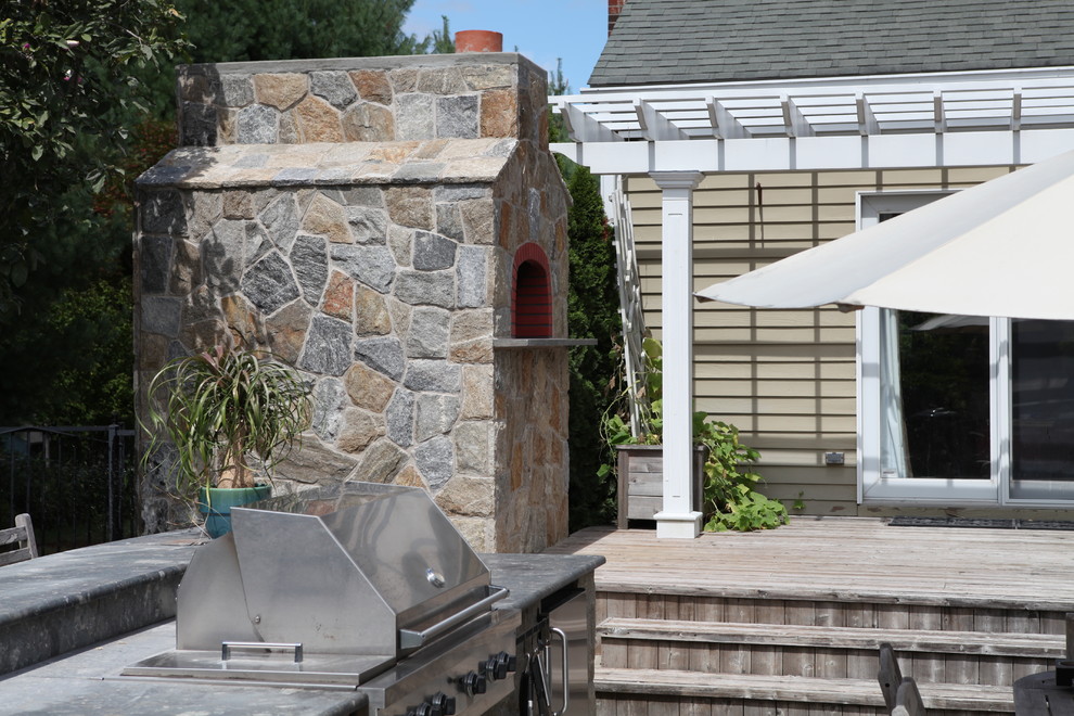 Ejemplo de patio clásico renovado grande en patio trasero con cocina exterior, entablado y pérgola