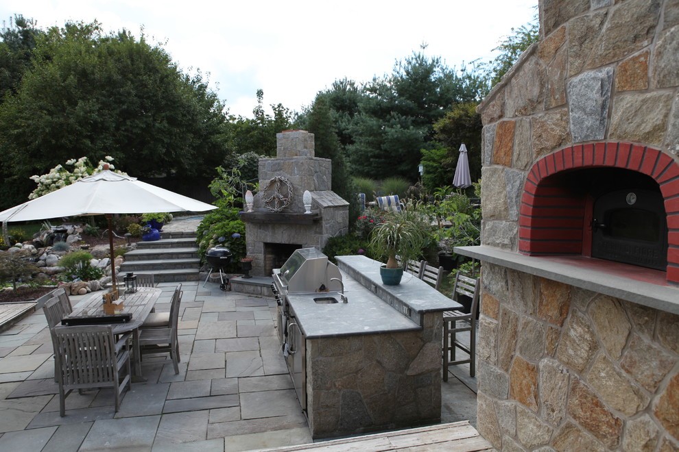 Imagen de patio clásico renovado grande en patio trasero con cocina exterior, entablado y pérgola
