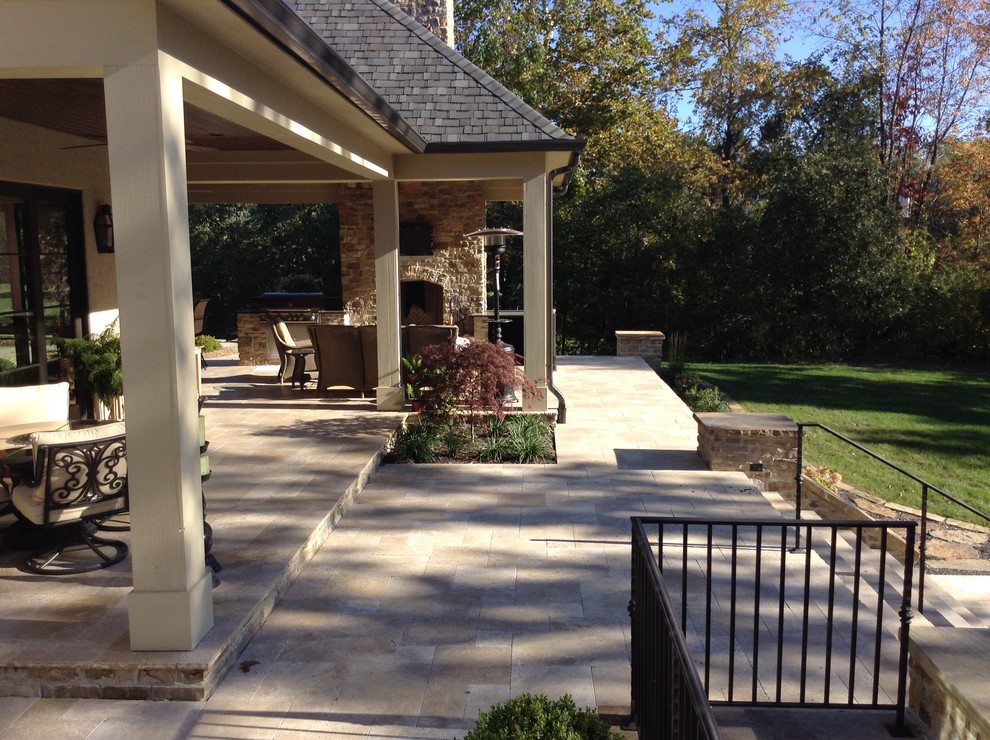 Imagen de patio clásico renovado grande en patio trasero con brasero y adoquines de piedra natural
