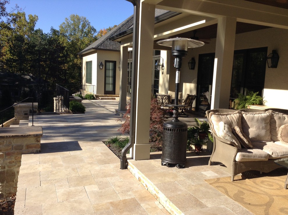 Esempio di un grande patio o portico tradizionale dietro casa con un focolare e pavimentazioni in pietra naturale