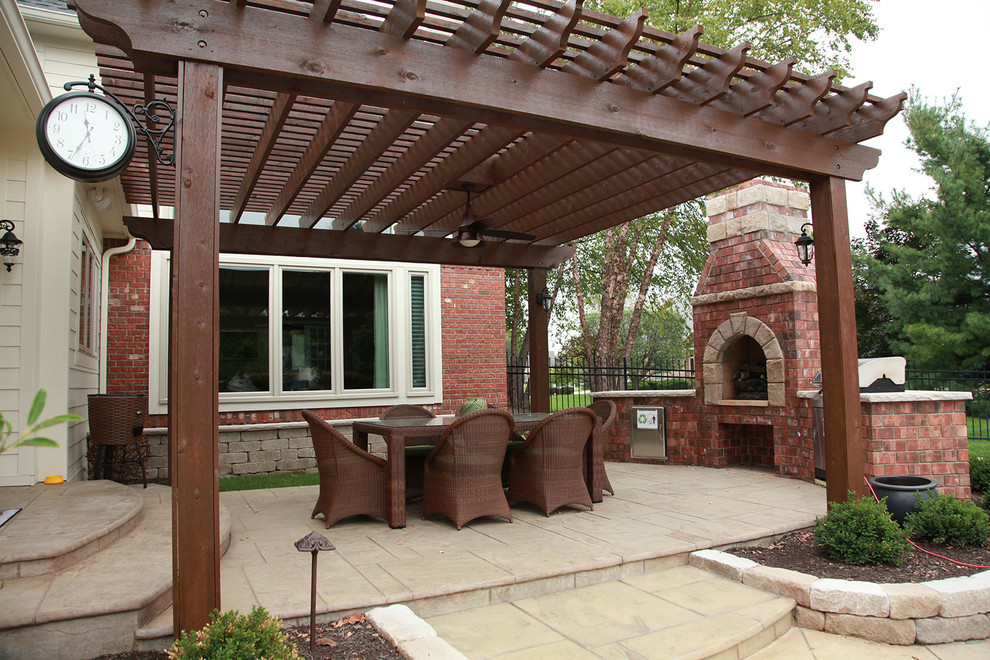 На фото: большой двор на заднем дворе в стиле кантри с летней кухней, покрытием из декоративного бетона и навесом с