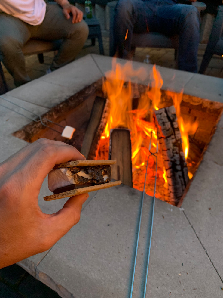 Medium sized rustic back patio in Chicago with a fire feature, concrete paving and a pergola.